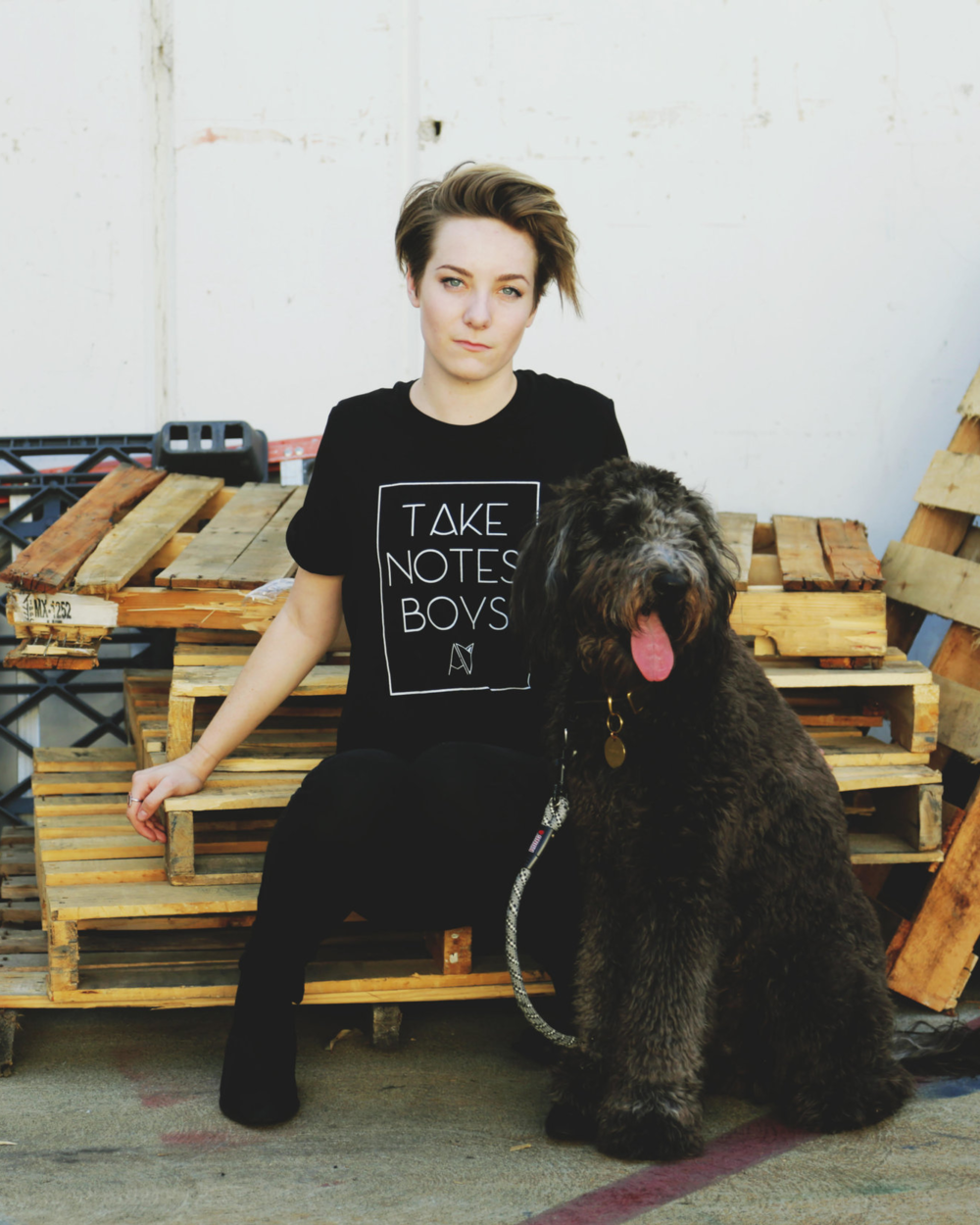 Girl with dog modeling black crew neck "take notes boys" t-shirt by Androgynous Fox.
