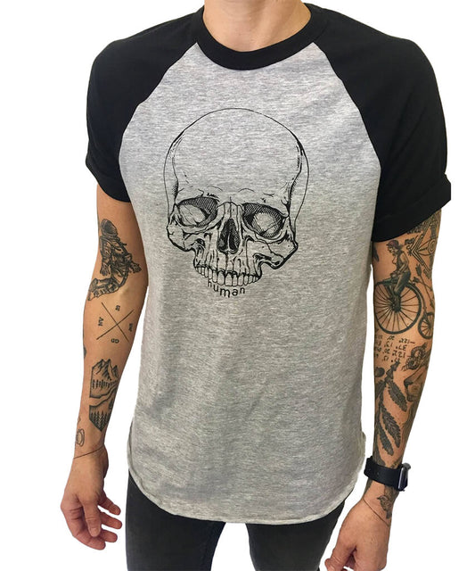 Model wearing Androgynous Fox short sleeve baseball tee with black sleeves and grey body. Skull is printed in black ink.